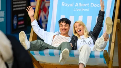 People sat in a large deck chair at the Royal Albert Dock