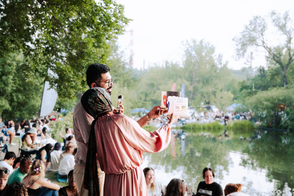 A couple stood by the waterside holding their lanterns up to take a picture